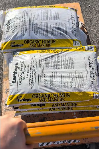 Bags of organic humus and manure compost loaded on a cart